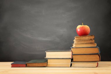 yazı tahtası önünde ahşap Resepsiyon üzerinde kitap yığını.