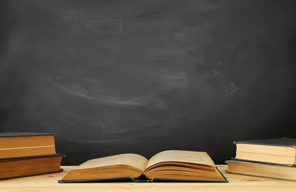 Pilha Livros Sobre Mesa Madeira Frente Quadro Negro — Fotografia de Stock