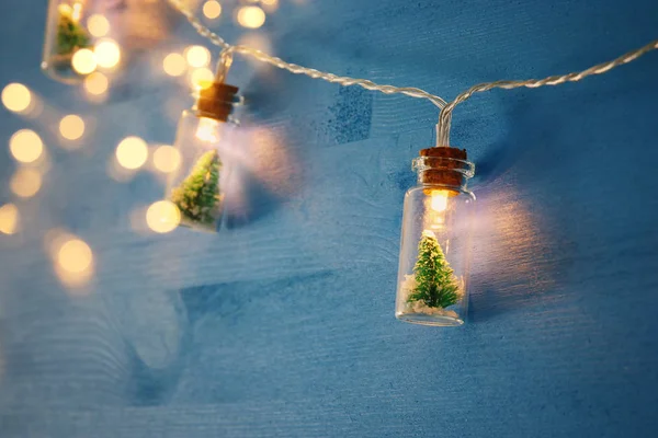 木製の青い背景にマッソン Jar 花輪光のクリスマス ツリーの画像を閉じる — ストック写真
