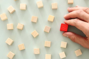 Tahta bloklar arasında bir farklı kırmızı küp blok. Bireysellik, liderlik ve benzersiz kavramı