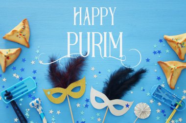 Purim kutlama kavram (Yahudi karnaval tatil) mavi ahşap arka plan üzerinde. Üstten görünüm