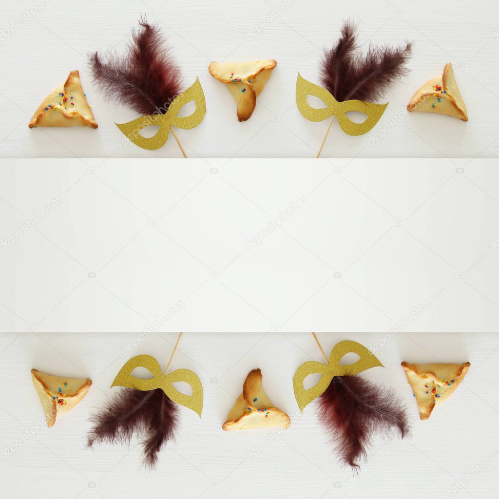 Purim celebration concept (jewish carnival holiday) over white wooden background. Top view