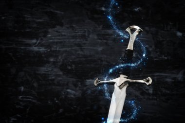 düşük anahtar görüntü sihirli ışıkları ile gümüş kılıç. fantezi Ortaçağ Dönemi