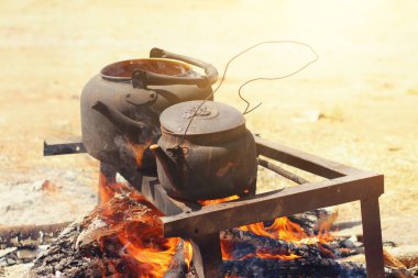 Yemek yemek ormandaki şenlik ateşi üzerinde rustik Eski çaydanlık