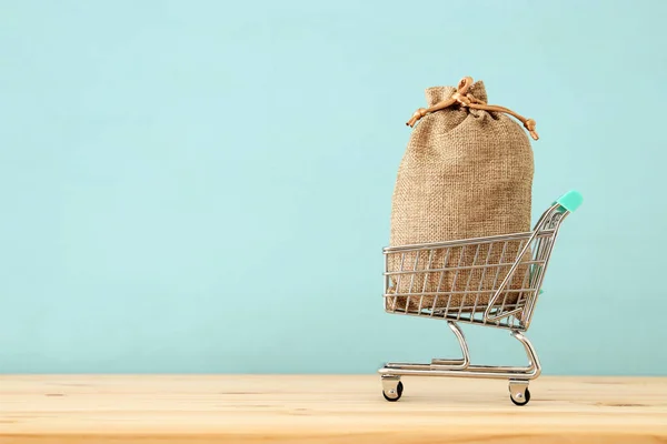 青い木製の背景上 完全袋いっぱいショッピングカート — ストック写真