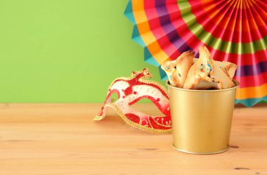 Purim kutlama kavram (Yahudi karnaval tatil) ahşap masa ve yeşil arka plan üzerinde