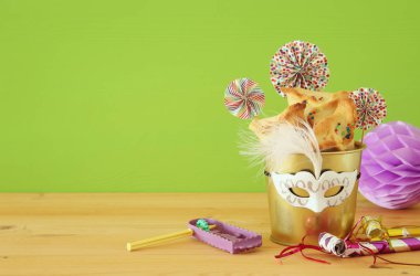 Purim kutlama kavram (Yahudi karnaval tatil) ahşap masa ve yeşil arka plan üzerinde