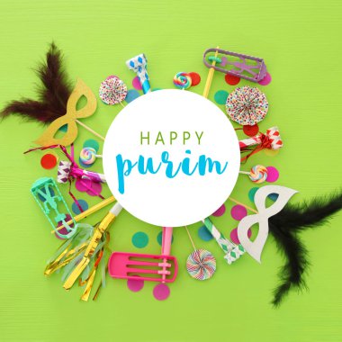 Purim kutlama kavram (Yahudi karnaval tatil) yeşil ahşap arka plan üzerinde. Üstten görünüm