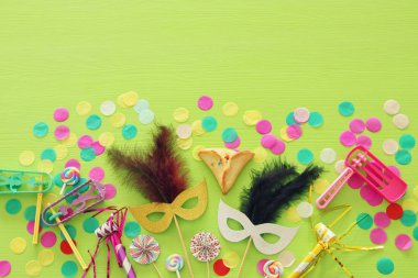 Purim kutlama kavram (Yahudi karnaval tatil) yeşil ahşap arka plan üzerinde. Üstten görünüm