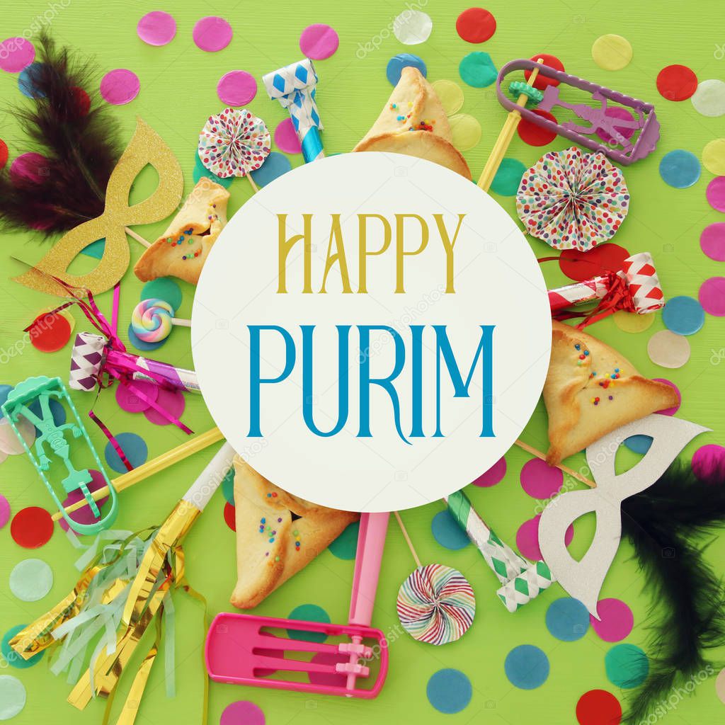 Purim celebration concept (jewish carnival holiday) over green wooden background. Top view