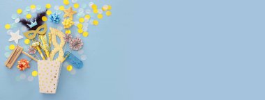 Purim kutlama kavram (Yahudi karnaval tatil) mavi ahşap arka plan üzerinde. Üstten görünüm. Afiş