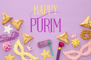 Purim kutlama kavram (Yahudi karnaval tatil) pembe ahşap arka plan üzerinde. Üstten görünüm