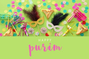 Purim kutlama kavram (Yahudi karnaval tatil) yeşil ahşap arka plan üzerinde. Üstten görünüm. Afiş