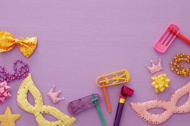 Purim kutlama kavram (Yahudi karnaval tatil) pembe ahşap arka plan üzerinde. Üstten görünüm