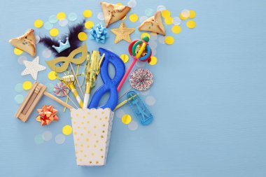 Purim kutlama kavram (Yahudi karnaval tatil) mavi ahşap arka plan üzerinde. Üstten görünüm. Afiş