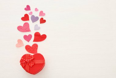 Sevgililer günü kavramı. Ahşap beyaz arka plan üzerinde kağıt kalpler. Düz yatıyordu