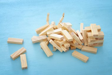 ahşap kukla yardımını domino taşları yığını altında gömülü. kavramı, stres, sıkıntı ve son tarih çok