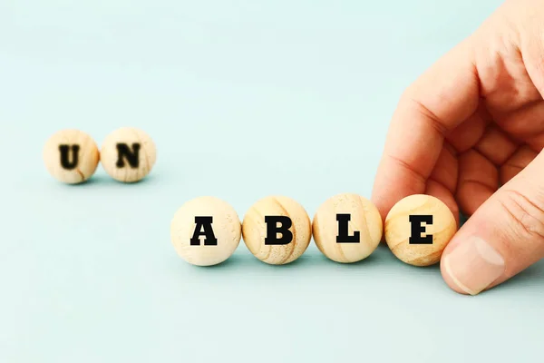Man Hand Spelling Text Unable Wooden Beads Taking Out Word — Stock Photo, Image