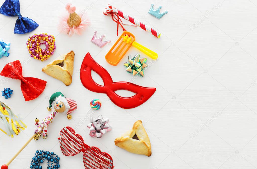Purim celebration concept (jewish carnival holiday) over wooden white background