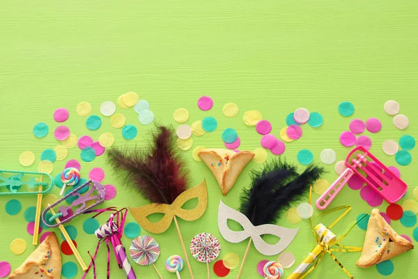 Purim kutlama kavram (Yahudi karnaval tatil) ahşap yeşil arka plan üzerinde.