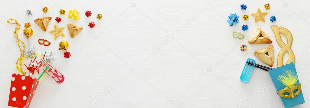 Purim celebration concept (jewish carnival holiday) over wooden white background. Banner