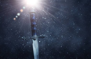 gizemli ve büyülü Gotik karlı siyah arka plan üzerinde gümüş kılıç fotoğrafı. Ortaçağ Dönemi kavramı