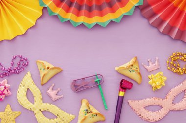 Purim kutlama kavram (Yahudi karnaval tatil) ahşap pembe bir arka plan üzerinde.