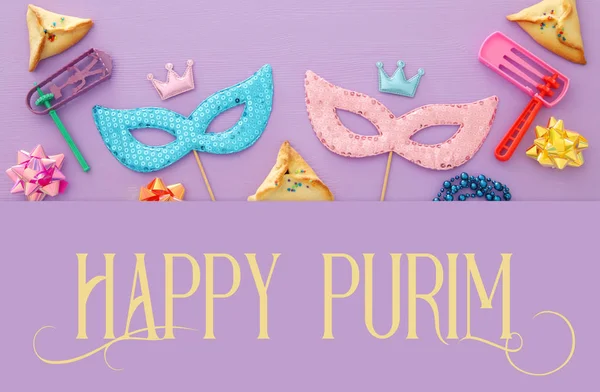 Purim kutlama kavram (Yahudi karnaval tatil) ahşap pembe bir arka plan üzerinde.