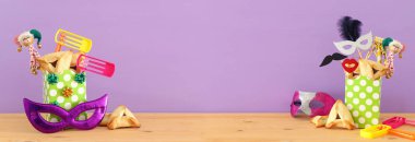 Ahşap masa ve mor arka plan üzerine Purim kutlaması konsepti (Yahudi karnavalı tatili)