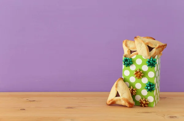 普林庆祝概念 犹太狂欢节假日 传统的哈曼塔琴饼干在木桌和紫色背景 — 图库照片