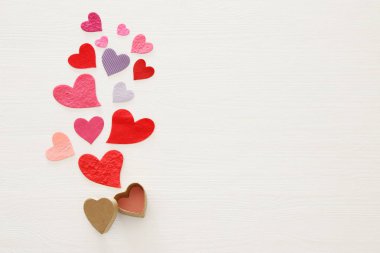 Sevgililer günü kavramı. Ahşap beyaz arka plan üzerinde kağıt kalpler. Düz yatıyordu