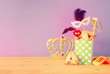 Ahşap masa ve mor arka plan üzerine Purim kutlaması konsepti (Yahudi karnavalı tatili).