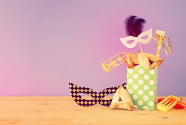 Ahşap masa ve mor arka plan üzerine Purim kutlaması konsepti (Yahudi karnavalı tatili).