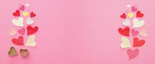 O conceito do Dia dos Namorados. Corações de papel sobre fundo rosa de madeira. Depósito plano . — Fotografia de Stock