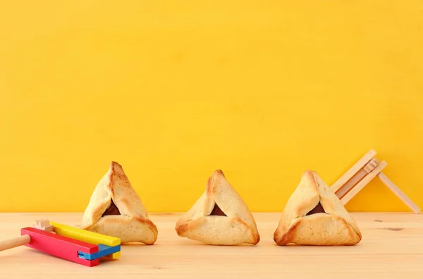 普林庆祝概念 犹太狂欢节假日 传统的哈曼塔琴饼干在木桌和黄色背景 — 图库照片