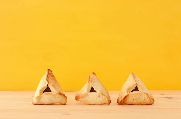 普林庆祝概念 犹太狂欢节假日 传统的哈曼塔琴饼干在木桌和黄色背景 — 图库照片