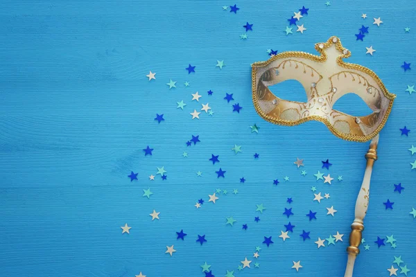 青い木製の背景と星を棒でエレガントなゴールド マスク カーニバル パーティーお祝い概念 トップ ビュー — ストック写真