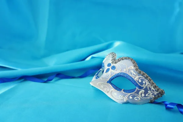 上品で繊細なの銀製および青いベネチアン マスク シルク ターコイズ ブルーの背景の上の写真 — ストック写真