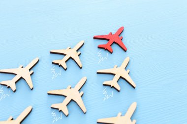 Liderlik kavramı mavi ahşap arka plan uçaklarda ile. Bir kırmızı lider önde diğerleri flays.