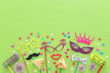 Purim kutlama kavram (Yahudi karnaval tatil) yeşil ahşap arka plan üzerinde. Üstten görünüm, düz lay