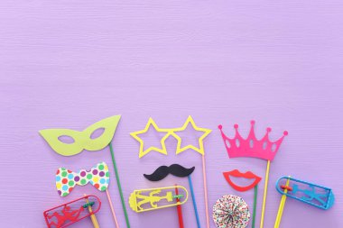 Purim kutlama kavram (Yahudi karnaval tatil) mor ahşap arka plan üzerinde. Üstten görünüm, düz lay
