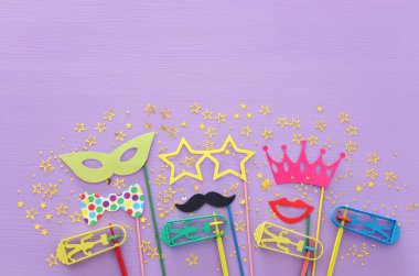 Purim kutlama kavram (Yahudi karnaval tatil) mor ahşap arka plan üzerinde. Üstten görünüm, düz lay