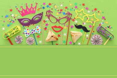 Purim kutlama kavram (Yahudi karnaval tatil) yeşil ahşap arka plan üzerinde. Üstten görünüm, düz lay