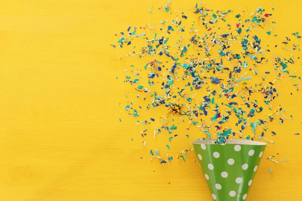 Party Bunte Konfetti Und Clownsmütze Über Gelbem Holzgrund Draufsicht Flache — Stockfoto