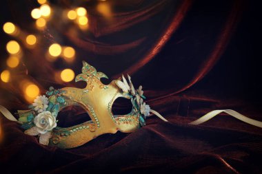 Narin ve zarif altın Venedik Maske üzerinde karanlık kadife ve ipek arka plan fotoğrafı