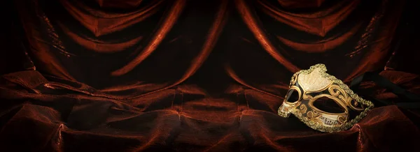 照片优雅和精致的黄金威尼斯面具在黑暗的天鹅绒和丝绸背景 — 图库照片