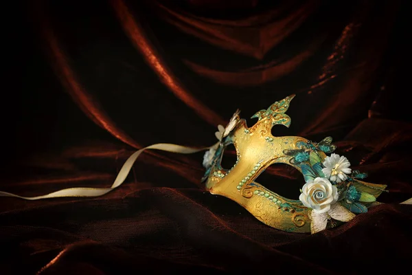 照片优雅和精致的黄金威尼斯面具在黑暗的天鹅绒和丝绸背景 — 图库照片