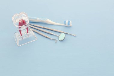 Dişçi klinikte için diş bakımı araçlarını kullanın. Mavi arka plan.