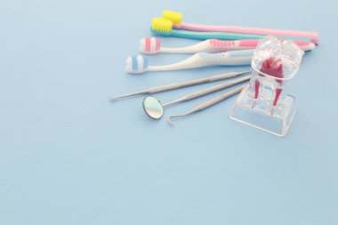 Dişçi klinikte için diş bakımı araçlarını kullanın. Mavi arka plan.