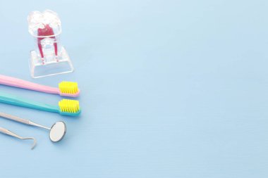 Dişçi klinikte için diş bakımı araçlarını kullanın. Mavi arka plan.